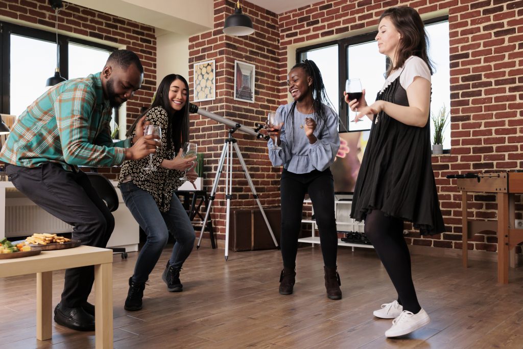 young adult people enjoying disco music at home while celebrating friendship anniversary event